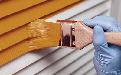Image of a person paining a wall orange